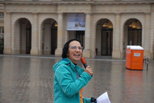 Birgitt Heine vom ADFC Cottbus Auf dem Bild ist Birgitt Heine vom ADFC Cottbus zu sehen. Sie hält ein Mikrofon und schaut in die Kamera.